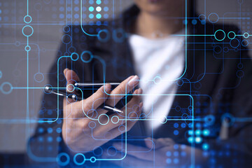 Businesswoman in formal wear holding in the hands a smart phone and testing an innovative application to provide a completely new service. Close up shot. Hologram tech graphs. Concept of Dev team.