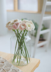 Beautiful pink ranunculus in big vase. Fresh bouquet at home. Cozy interior.