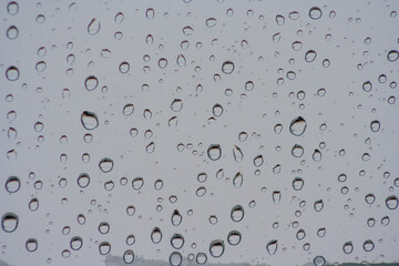 Drops of rain on the window or glass. Gray wet glass pattern texture. Abstract background