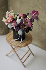 Floral bunch in round black box. Fresh delicate bouquet of beautiful Mixed flowers on wooden table. Excellent garden flowers in the arrangement , the work of a professional florist. Gift box