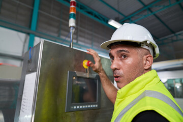 European Engineer is pressing the emergency button on control box with shocked face in beverage...