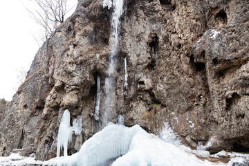 Fototapeta na wymiar Partially frozen honey falls in January