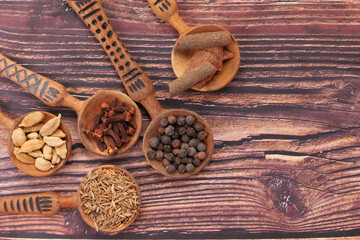Spices and herbs on spoon on table, top view 