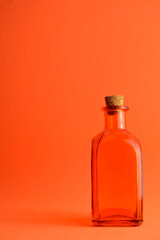 Orange glass bottle on orange background.