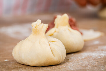 Cooking, cooking homemade ravioli, dumplings or meat dumplings on a wooden table. The view from the top