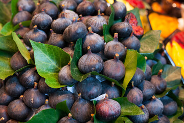 ripe figs with leaves on counter in market