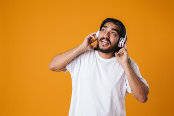 Happy young indian man listening to music