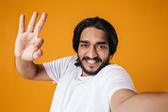 Smiling indian man taking a selfie isolated