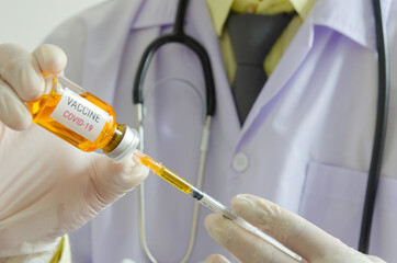 Doctors holding a syringe and a bottle of COVID-19 vaccine. Medical experimental vaccine treatment