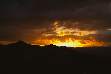 Fiery sunset in the mountains. Beautiful light from the sun.