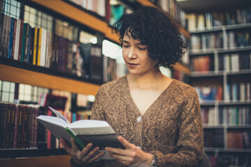 woman in library reading book. 