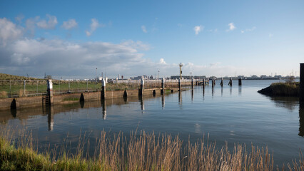 Fototapeta na wymiar Quay wall of the small harbor in the polder village of Doel in Belgium at high tide