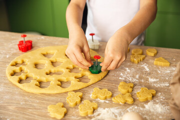 Indoor activity. Young child boy cooking in the kitchen. Making cookies. Closeup