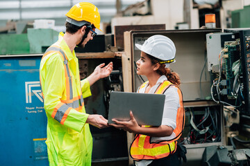 Work at factory.engineer and workers team working together in safety jumpsuit uniform with white and yellow helmet using laptop computer.in factory workshop industry concept professional