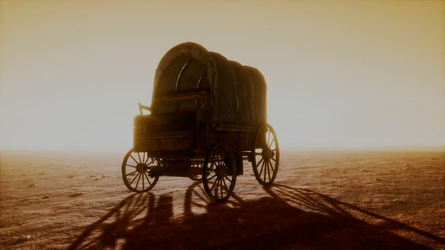 canvas covered retro wagon in desert at sunset