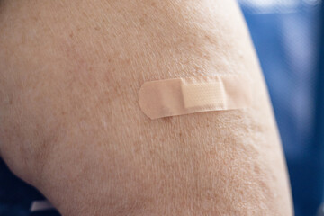 a patch on the forearm of an elderly woman after the vaccine