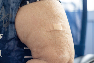 a patch on the forearm of an elderly woman after the vaccine