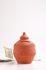 Clay piggy bank pot with five hundred rupees bank note in indian currency on white background