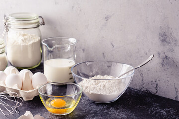 Cooking ingredients for dough, eggs, flour, sugar, milk.