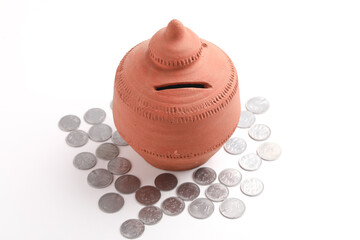 Clay piggy bank pot with Indian rupees coin over white background. saving concept