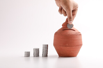 putting a coin into a clay money box: investments, retirement fund and banking concept