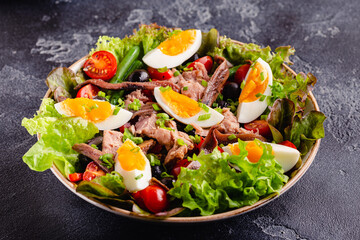 salad Nicoise with tuna, eggs, green beans, tomatoes,  olives, lettuce and anchovies