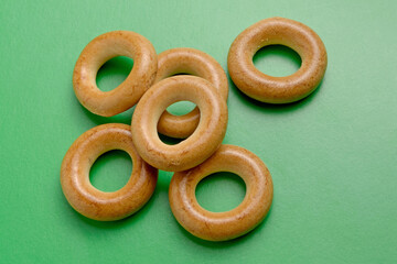 Baked dough rings on a green background close-up