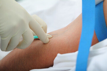 Doctor makes the patient an injection into the elbow bend
