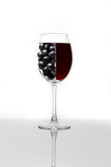 A glass of red wine with grapes