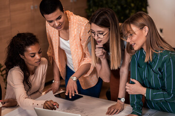 Group of women working together discussing architectural designs in the creative office.