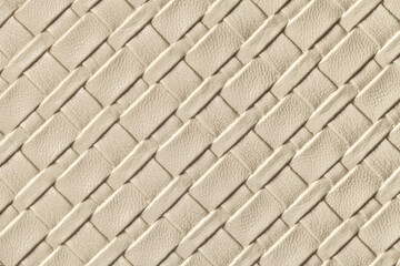 Texture of light beige and sand leather background with wicker pattern, macro.