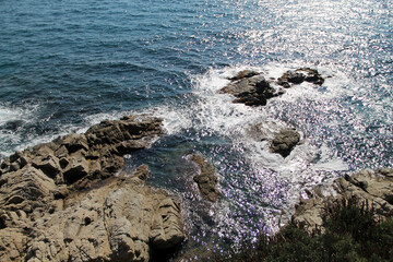 waves on the rocks. beautiful view of the Mediterranean sea. sea waves break on stones. blue water near the rocks with sunshine