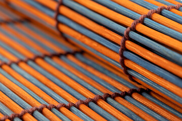 Bamboo mat closeup. Oriental eco fiber. Natural product. Wooden material, striped texture.