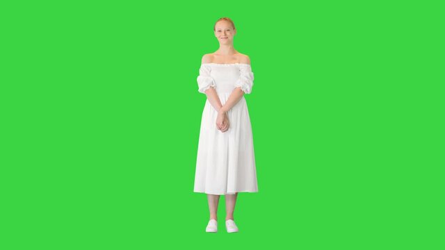 Beautiful Woman in White Dress posing to camera on a Green Screen, Chroma Key.