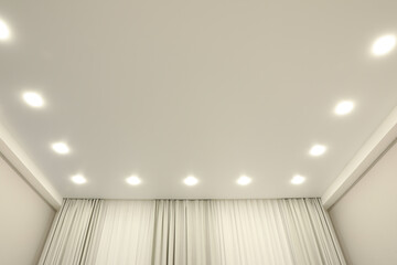 White stretch ceiling with spot lights in room