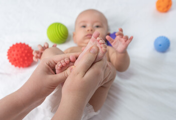 Doctor giving foot massage to baby. Selective focus