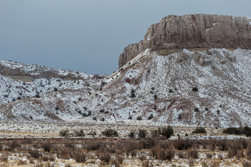 Majestic snow covered mesa plateau in desert vista landscape in rural New Mexico on overcast day