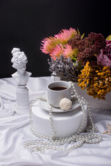 Breakfast in a mature style. A statuette and a cup of coffee