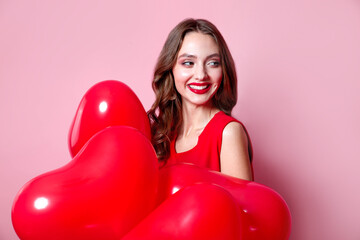 Valentine day. Beauty girl with red heart air balloon portrait on pink background. Birthday party,