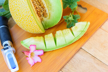 Closeup to sweet Fresh green melon on wood plate