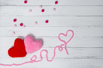 .Valentine's day .Red and pink knitted volume heart in the word love on white wooden background. Template for design, valentines card, invitation. Copy space Top view