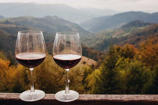 Two glasses with red wine standing with a scenic mountain view