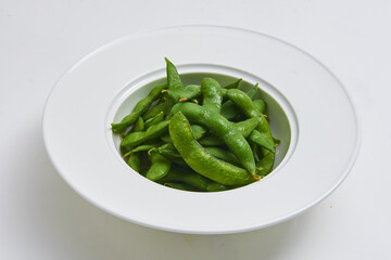 Hot Japanese Edamame Served on a white plate, appetizer menu