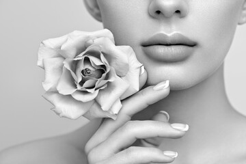 Beautiful model with a rose. Perfect woman face makeup close up. Beautiful nails.  Black and white...