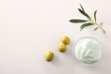 Olive moisturizing cream for skin on white table top detail