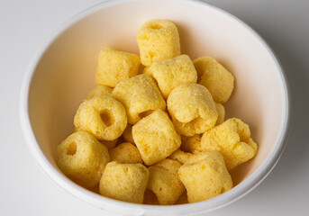 Crispy Corn rings salty snacks in bowl. Fast food or junk food snacks unhealthy concept.