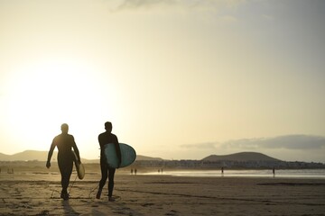 walking with surfboard on the beach
