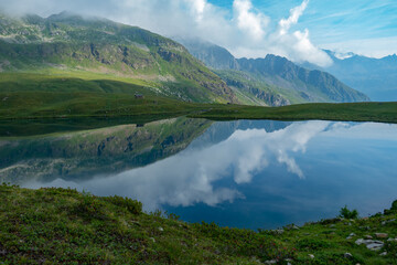 Naklejka na ściany i meble Lago di Malghera in the Italian Alps: Beautiful reflections of mountains and sky