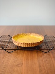 Homemade baked shortcrust pastry base (or case) on a cooling rack