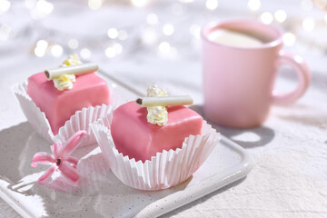 Valentine petit fours with marzipan icing and cream flowers. Espresso coffee in pink cup. Happy...